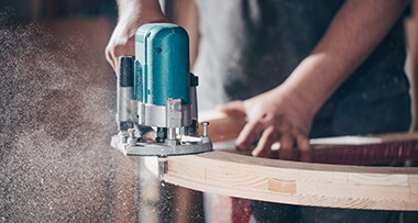 a joiner using a planer on a curved section of wood on a carpentry project