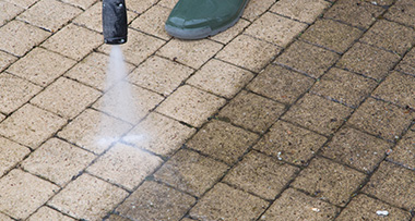 a person using a pressure washer to clean their patio