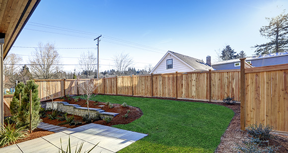 a garden with a newly installed fence on the perimeter 