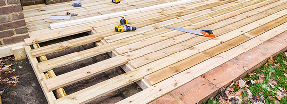 a decking in the midst of being installed in a back garden