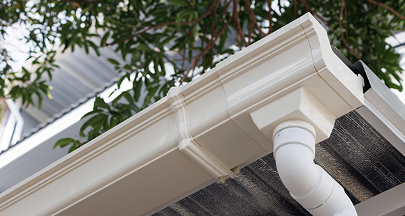 a plastic gutter with a drainage pipe attached underneath at the end